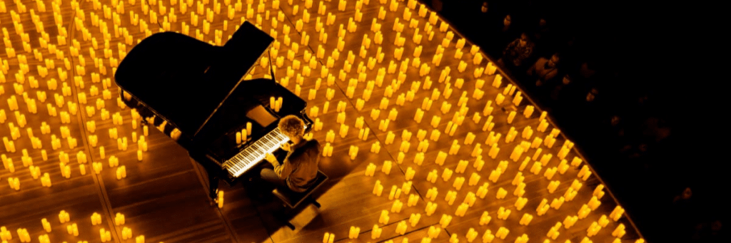 Photo en contre plongée d'un pianiste jouant sur un piano à queue un concert Candlelight
